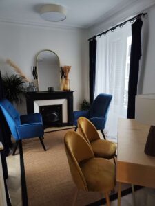 Cabinet de consultation à Lyon 2- 69002 lumineux et chaleureux avec fauteuils, cheminée décorative, rideaux clairs et ambiance apaisante.