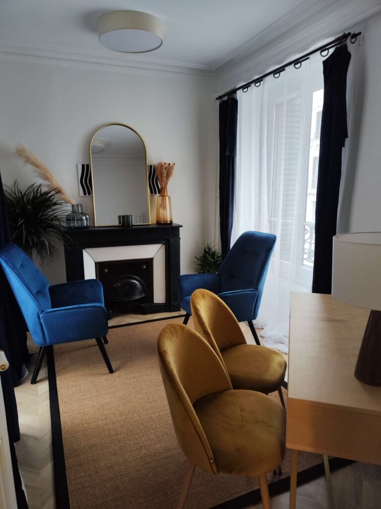 cabinet de consultation lumineux et chaleureux avec fauteuils, cheminée décorative, rideaux clairs et ambiance apaisante.