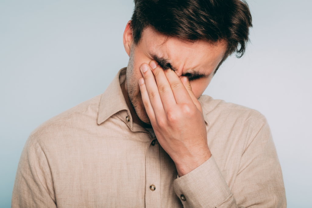 Homme ressentant du stress et de l’anxiété, main sur le visage