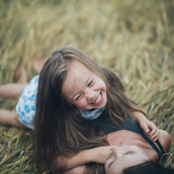 Mère et fille rigolants allongées dans un champs